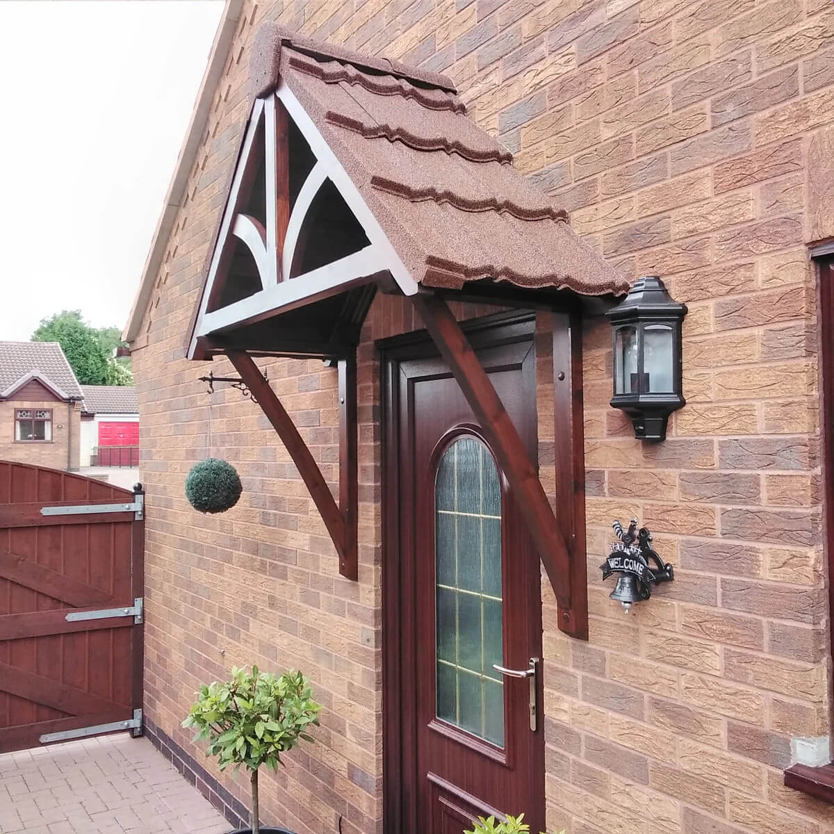 Brown door with decorative canopy featuring a roof using granulated brown Lightweight Tiles.