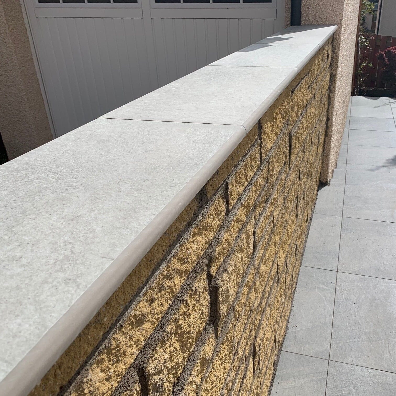 Castle Hammerstone Grey porcelain coping stones installed on a rendered garden wall, creating a neat modern finish with effective rainwater protection