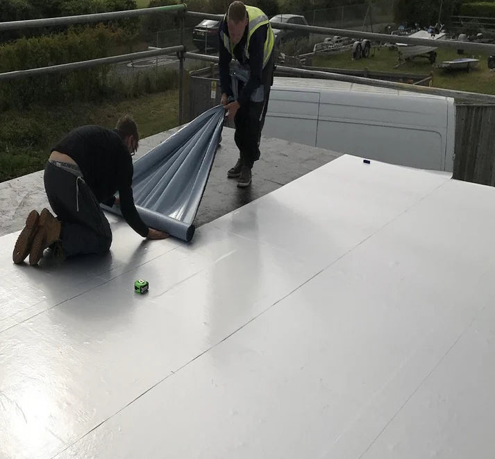 Roofers installing Eagle GR100 Self Adhesive Vapour Control Layer on roof deck using cold-applied method