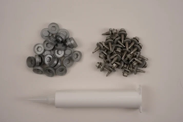 Collection of metal washers and screws on a white background with a white syringe.