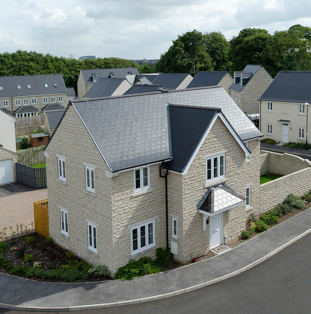 Graphite fibre cement roof slates with textured riven surface and dressed edges on pitched roof