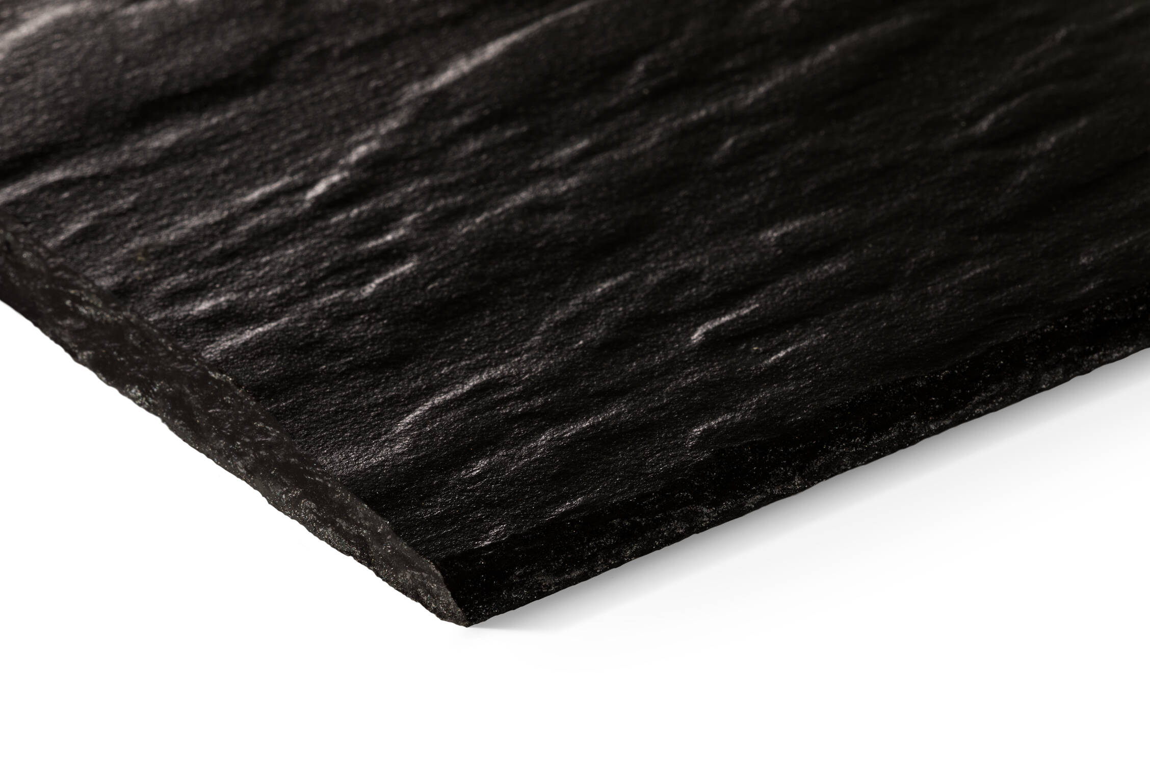 Close-up of a graphite roof slate with a textured surface on a white background