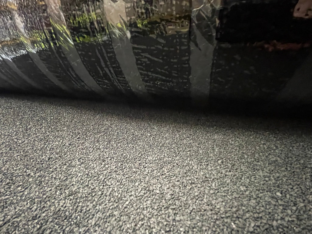 Detailed view of StrataBit Rapid-O bituminous capsheet partially unrolled showing mineral top layer and roll form