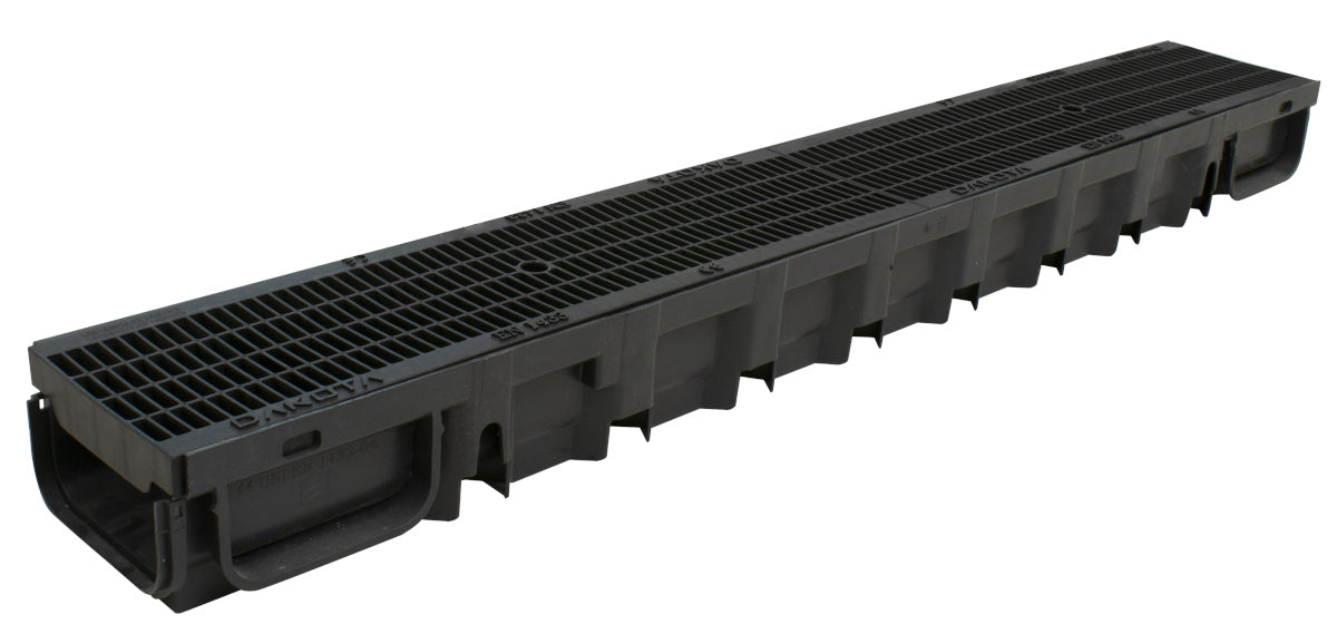 A complete view of a black channel drain with a slotted grate on top.