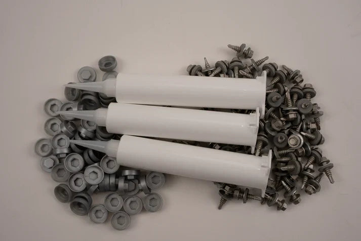Three white plastic tubes surrounded by metal screws on a light grey background