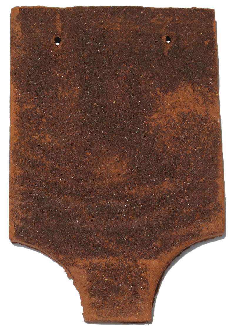 Close-up of a handmade Tudor Fishtail Tile with a distinctive scalloped edge and textured clay finish

