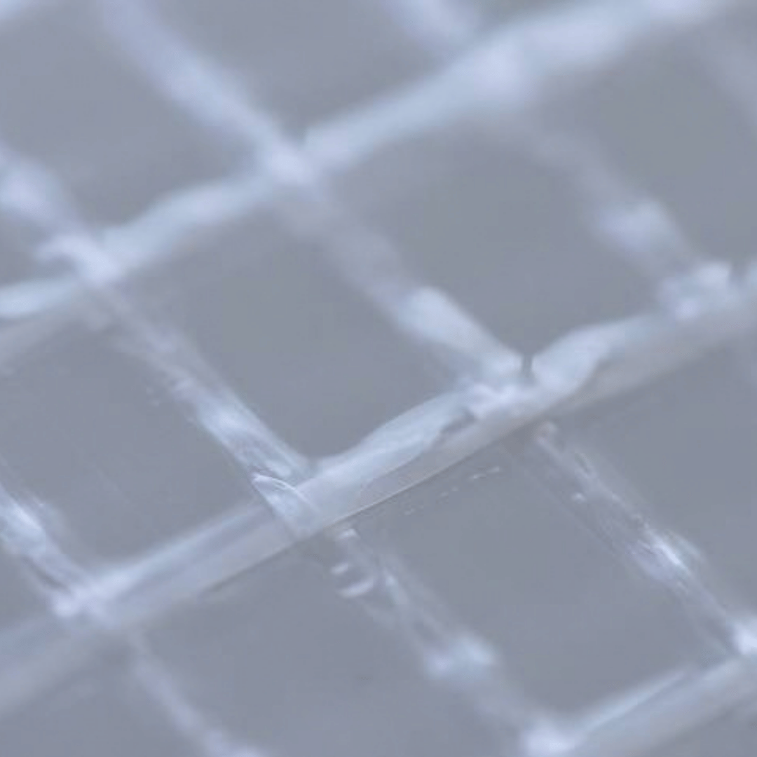 A close-up view of a translucent white grid or lattice pattern, showing a soft-focus texture with light gray highlights.