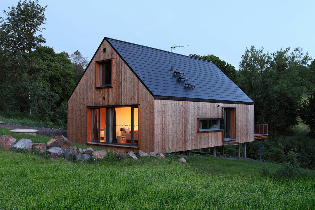 Modern wooden cabin with graphite fibre cement roof slates in a natural setting