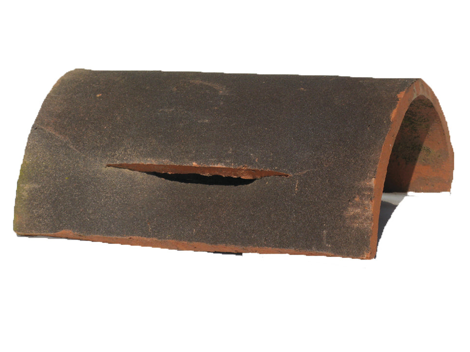 Handmade clay half round ridge tile featuring integrated vents for airflow on pitched roofs