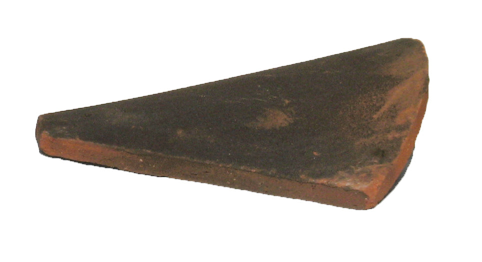 Side view of handmade clay Sussex hip tile with curved bonnet profile for roof hips