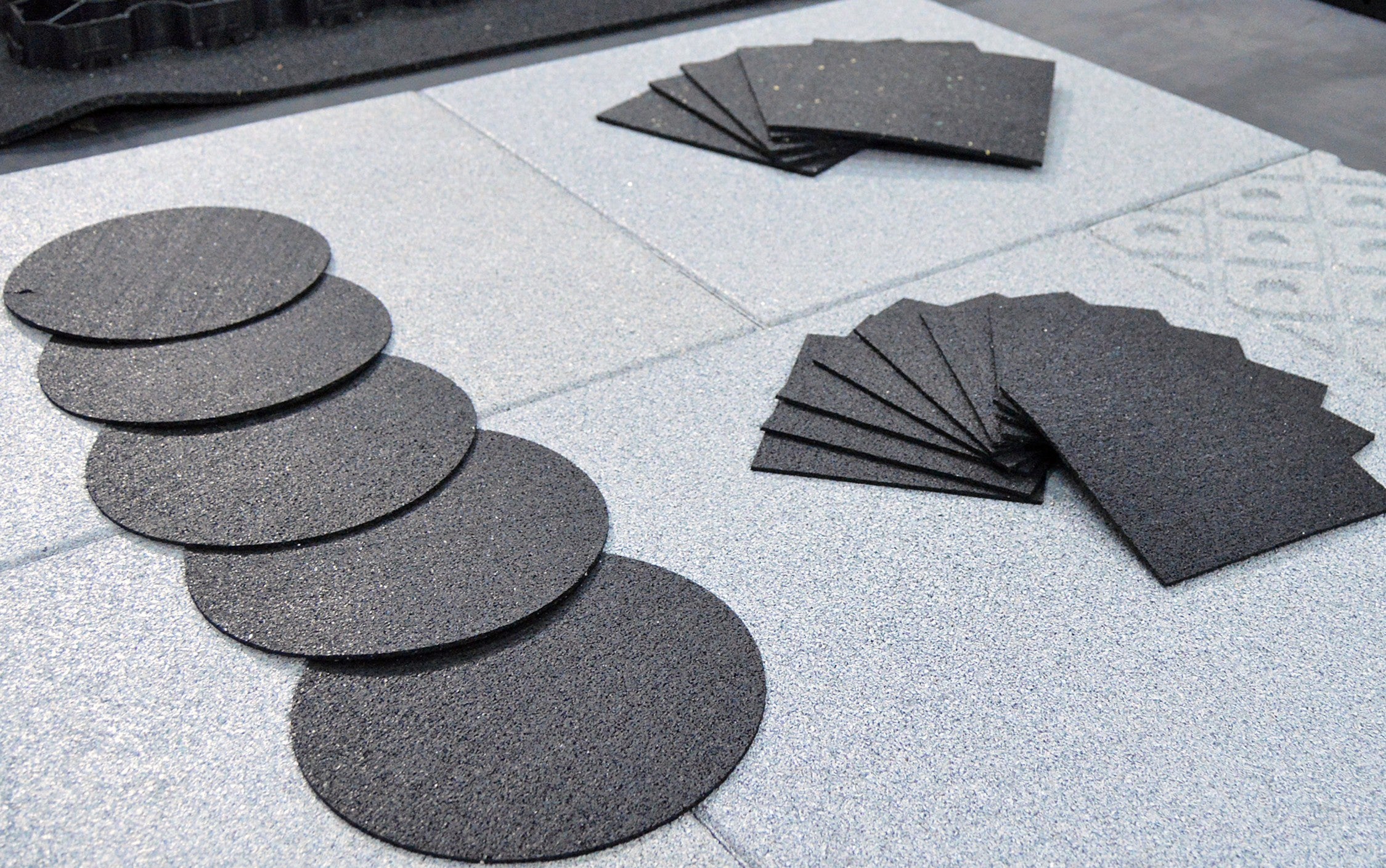 Rubbertech ecotred sacrificial base pads in square and circular shapes laid out together showing recycled rubber construction