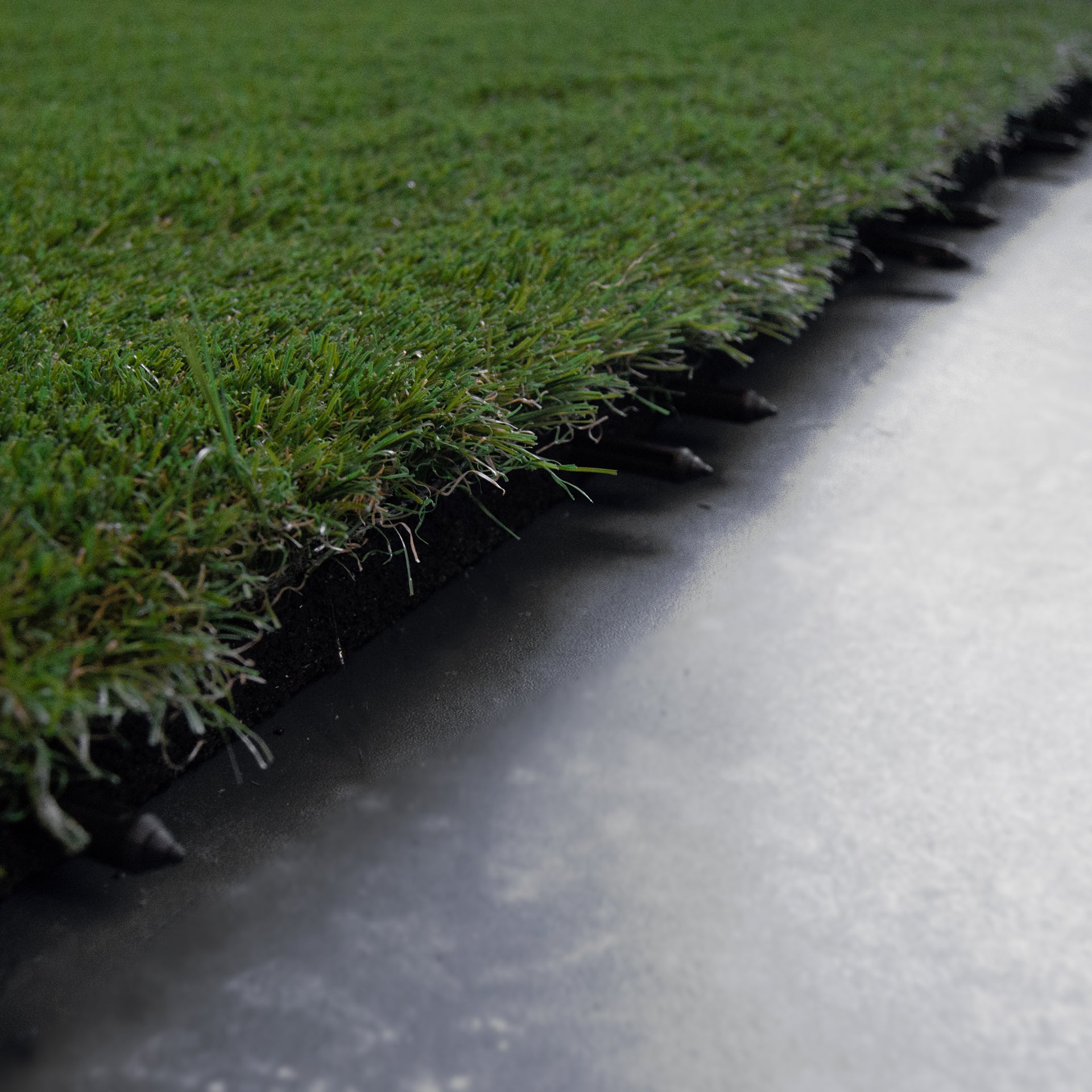 Side view of an installed Rubbertech ecotred Turf tile showing the integrated dowel peg connection system